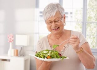 older woman eating vegetables