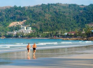 Healthy mature couple running beach