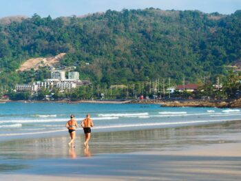 Healthy mature couple running beach